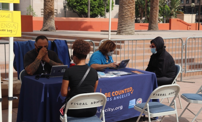 Census takers helping people fill out the census at an outreach event.