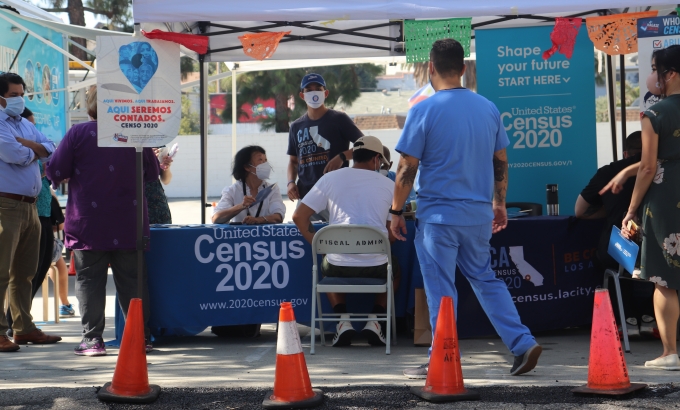 Guests waiting to fill out their census with Census Bureau employees at an outreach event.